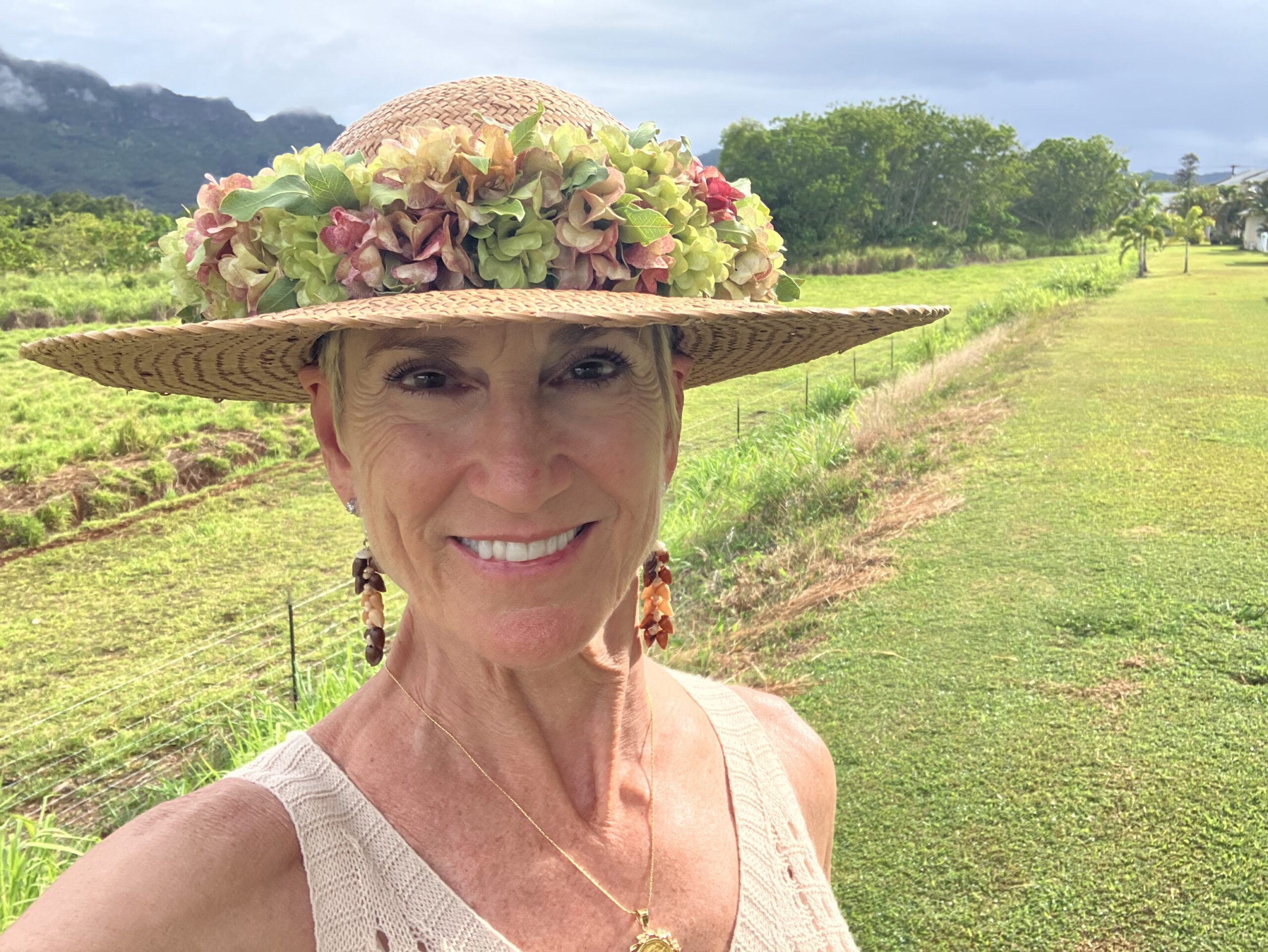 Personal photo of Carol Simon in a field by. a mountain on Kaua'i